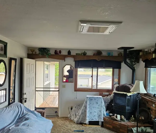 Ceiling cassette mini-split installed flush into the ceiling of an occupied living room, with only the low-profile grille visible above the doorway